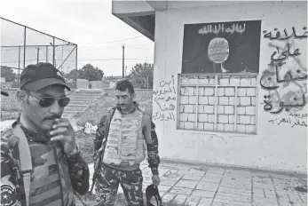  ?? OSIE GREENWAY ?? Iraqi police check out a building firebombed by a resistance group named the Hawija Boys.
