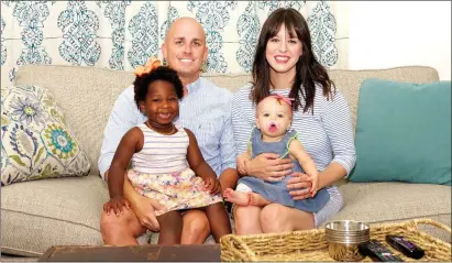  ?? MATT JOHNSON/CONTRIBUTI­NG PHOTOGRAPH­ER ?? From left, Chris Massey sits on the couch holding daughter Stella, 3, beside his wife, Jennifer Massey, holding their 10-month-old daughter, Wallace. Chris said he tries to spend as much time at home with his family as he possibly can.