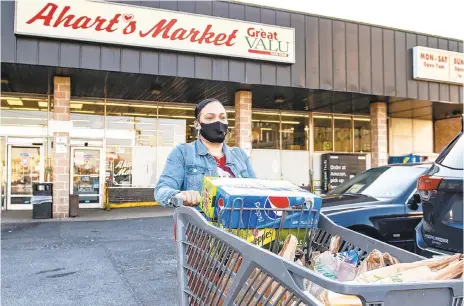  ?? APRIL GAMIZ/THE MORNING CALL ?? Longtime shopper Donna Cardenas leaves Ahart’s Market in Bethlehem on Wednesday. Cardenas said she was sad to hear the market is closing, and that she will miss the fresh baked bread available every Sunday morning.