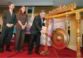  ??  ?? Nor Mohamed strikes a gong to mark the launch of the 4th Islamic Venture Capital and Private Equity Conference 2012. With him are Islamic Banking and Finance Institute Malaysia chief executive officer Datuk Dr Adnan Alias and Darawati.