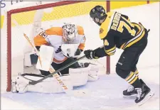  ?? FRANK GUNN - THE ASSOCIATED PRESS ?? Flyers goalie Carter Hart turns aside a shot by Bruins left wing Jake DeBrusk during the first period Sunday, one of 30 saves in a 4-1 win over Boston in the NHL playoffs qualifying round.