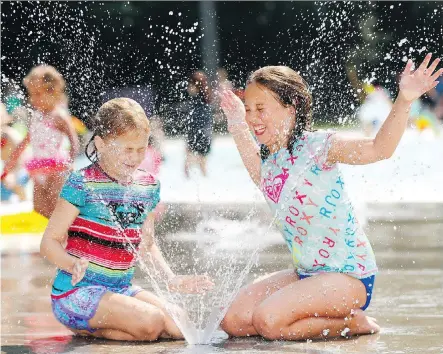  ?? DARREN MAKOWICHUK ?? From left, Sienna Henderson, 8, and Taylor Olesko, 9, cool down at the Bowness Park wading pool as Calgary set a heat record for Aug. 9, hitting 33 C on Thursday, topping the previous mark of 32.7. Friday is expected to near the city’s all-time high of 36.1 C, set in 1919 and 1933.