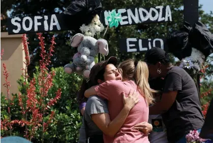  ?? ?? Mourners embrace at a memorial set up near the scene of the mass shooting at the Allen Premium Outlets mall in Allen, Texas. Photograph: Joe Raedle/Getty Images