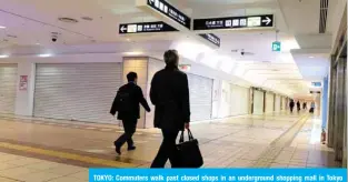  ??  ?? TOKYO: Commuters walk past closed shops in an undergroun­d shopping mall in Tokyo railway station.— AFP