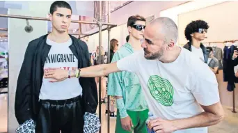  ??  ?? El diseñador mexicano Ricardo Seco (der.) llevó a la pasarela su protesta contra la política migratoria de Trump. Se inspiró en las Olimpiadas de 1968 en México para su nueva colección primavera-verano, que presentó ayer NY.