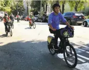  ?? Michael Cabanatuan / The Chronicle ?? Riders test Ford GoBikes with electric pedal assist as they head up Page Street in Hayes Valley.