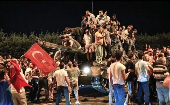  ?? DEFNE KARADENIZ/GETTY IMAGES ?? People clamber atop a Turkish army tank at Istanbul’s Ataturk airport early Saturday during an attempted military coup. Thousands of people took to the streets at the president’s urging.