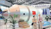  ?? AP FILE ?? Visitors in front of a model of China's Tiangong1 space station at an aviation and aerospace exhibition in Guangdong.