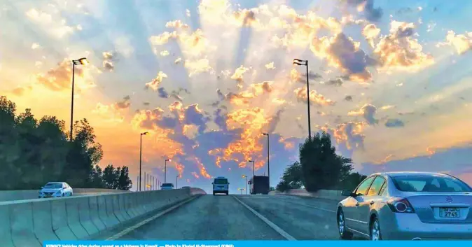  ?? — Photo by Khaled Al-Shammari (KUNA) ?? KUWAIT: Vehicles drive during sunset on a highway in Kuwait.