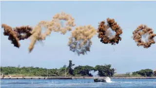  ??  ?? ... An amphibious assault vehicle throws smoke bombs during a military drill at a navy base in the Taiwanese city of Kaohsiung yesterday.