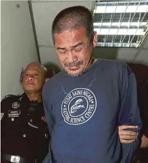  ?? [FOTO ROSDAN WAHID/BH] ?? Anggota polis membawa tertuduh keluar dari Mahkamah Majistret Ampang, semalam.