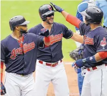  ?? TONY DEJAK/ASSOCIATED PRESS ?? Cleveland’s Lonnie Chisenhall, center, is congratula­ted by Edwin Encarnacio­n, right, and Carlos Santana after hitting a three-run pinch-hit homer for the Indians on Thursday against the Dodgers.