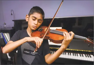  ?? Erik Trautmann / Hearst Connecticu­t Media ?? Arav Amin practices violin in the dining room of his home Tuesday in Norwalk. Amin, a Roton Middle School sixth-grader, attends the Juilliard Music Advancemen­t Program with other top local musicians ages 8-17.