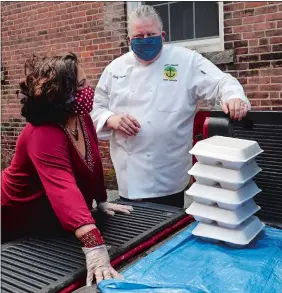  ?? DANA JENSEN/THE DAY ?? Chef Tomm Johnson, culinary program manager at New London High School, right, talks to Lizbeth Polo, program coordinato­r with Hispanic Alliance of Southeaste­rn Connecticu­t, while they and volunteers load meals into a pickup truck for the Hispanic Alliance on Saturday at the New London Lodge of Elks. On Saturday, New London Human Services helped organize a drive-thru for families that called the help line at the Drop In Learning Center.