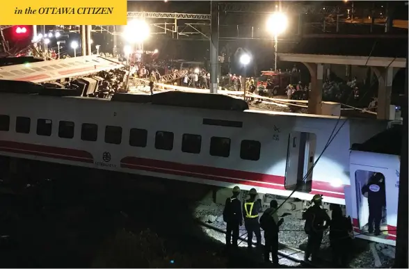  ?? JOHNSON LAI / THE ASSOCIATED PRESS ?? Rescue workers gather at the site of a fatal train derailment in Lian county in northern Taiwan on Sunday. There was no immediate word on the cause of the accident.