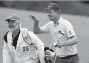  ?? CURTIS COMPTON AP ?? Justin Rose and caddie David Clark react to his second shot on No. 18 on the way to a 7-under 65 in tough conditions at Augusta National.