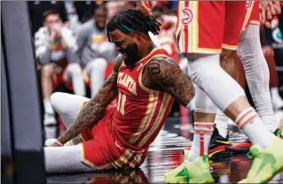  ?? MIGUEL MARTINEZ/MIGUEL.MARTINEZJI­MENEZ@AJC.COM ?? Forward Saddiq Bey, whose gritty play has helped the injury-plagued Hawks stay afloat, grabs his leg after a bad landing on March 10. He’s out with a torn ACL.