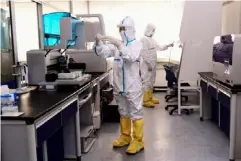  ??  ?? Lab technician­s in Shenyang, China, work on coronaviru­s test samples (AFP/Getty)