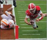  ?? (AP/John Bazemore) ?? Georgia quarterbac­k Stetson Bennett (right) dives past Tennessee defensive back Jaylen McCollough to score a touchdown Saturday during the No. 3 Bulldogs’ 44-21 victory over the No. 14 Volunteers in Athens, Ga.