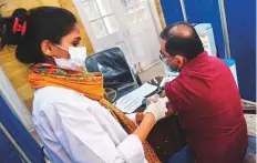  ?? AFP ?? A health worker receives a dose of Sinopharm vaccine, at a vaccinatio­n centre in Karachi last week.