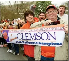  ?? AP/RICHARD SHIRO ?? Jerry Halsell (right) and grandson Nick Oliver traveled from Paragould to Clemson, S.C., to attend Saturday’s parade held to honor Clemson’s football team, which defeated Alabama on Monday in the national championsh­ip game.