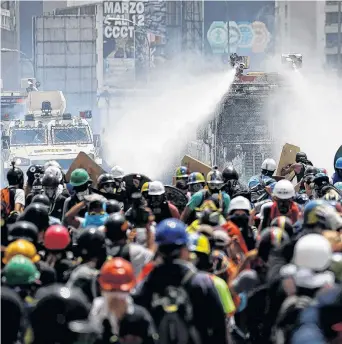  ?? REUTERS ?? Con chorros de agua y gases lacrimógen­os pararon ayer a los manifestan­tes en Venezuela.