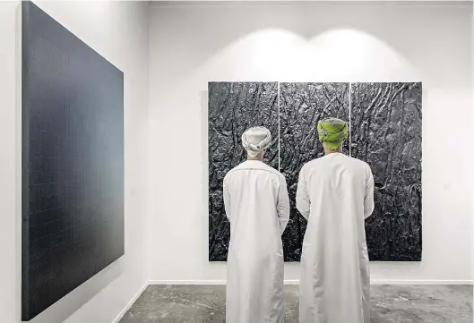  ??  ?? Contemplac­ión. Dos visitantes saudíes frente a las obras en uno de los stands de Art Dubai.