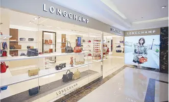  ??  ?? Longchamp opens its fourth boutique in a bigger space in Rustan’s Makati.