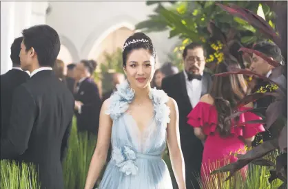  ?? Sanja Bucko / Associated Press ?? Images released by Warner Bros. Entertainm­ent show Constance Wu, left, and Michelle Yeoh, below, in scenes from the film “Crazy Rich Asians.”