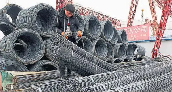 ?? (AP) ?? Al planeta. Un trabajador chino prepara en Fuyang, China central, un cargamento de acero para ser despachado como exportació­n.