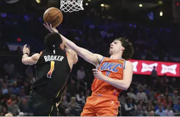  ?? KYLE PHILLIPS — THE ASSOCIATED PRESS ?? Oklahoma City Thunder guard Josh Giddey (3) shoots against Phoenix Suns iguard Devin Booker (1) during the second half of an NBA basketball game Friday, March 29, 2024, in Oklahoma City.