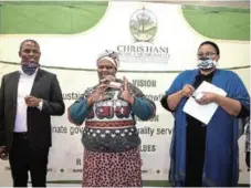  ?? Picture: ANDISA BONANI ?? HELPING THE NEEDY: The CHDM foodbank made its first distributi­on of donated items by local businesses with hawker Eunice Fani, middle, showing off her grocery voucher flanked from left by CHDM mayor Wongama Gela and his deputy Noncedo September