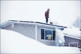  ?? Loren Holmes/associated Press ?? Doug Hamrick, 14, shovels snow off of his family's roof Thursday in Anchorage. More than seven feet has fallen in the city since November, with more on the way.