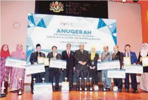  ?? [FOTO AHMAD IRHAM MOHD NOOR/BH] ?? Aidie (tengah) bergambar bersama-sama penerima anugerah pada majlis Anugerah Kecemerlan­gan Jalinan Sekolah Kluster Kecemerlan­gan-universiti Awam 2018 di Putrajaya, semalam.