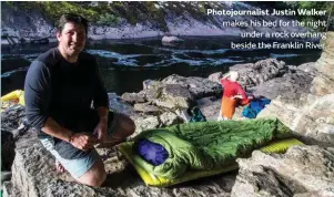  ??  ?? Photojourn­alist Justin Walker makes his bed for the night under a rock overhang beside the Franklin River.