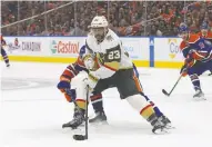  ?? LAWRENCE SCOTT / GETTY IMAGES ?? Ryan McLeod of the Edmonton Oilers uses his stick to slow up Alec Martinez of the Las Vegas Golden Knights
during a recent playoff game in Edmonton.