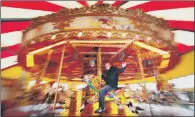  ??  ?? MERRY AFTER ALL: Auctioneer Carl Vince trying out the 114-year-old carousel from Pleasure Island Cleethorpe­s.