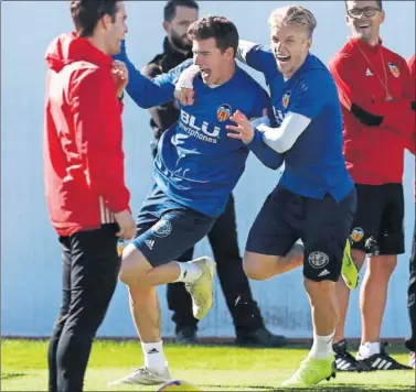  ??  ?? LA ALEGRÍA DEL VALENCIA. Santi Mina, agarrado por Wass, bromeando en el entrenamie­nto de ayer.