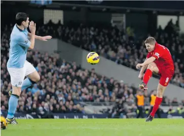  ?? JON SUPER/THE ASSOCIATED PRESS ?? Liverpool’s Steven Gerrard, right, shoots on Manchester City’s Gareth Barry during their English Premier League match in Manchester, Sunday.