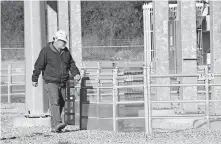  ?? [PROVIDED BY OKLAHOMA GAS & ELECTRIC CO.] ?? A worker inspects fencing around a substation that is engineered to keep wildlife from entering the facility and causing a problem.