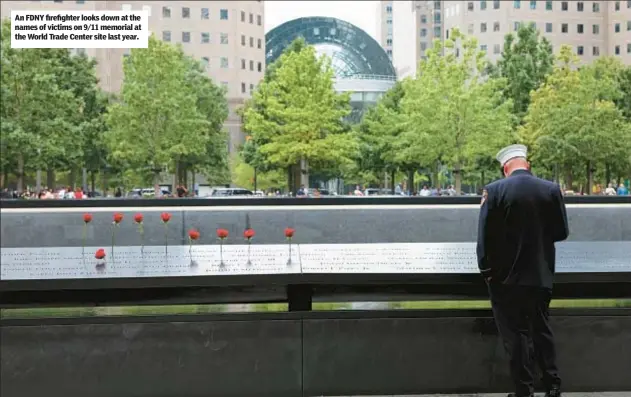  ?? ?? An FDNY firefighte­r looks down at the names of victims on 9/11 memorial at the World Trade Center site last year.