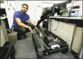  ?? Associated Press ?? Software engineer Nicholas Otero, of Woburn, Mass., speaks with a colleague about a Centaur robot, right, at Endeavor Robotics in Chelmsford, Mass.