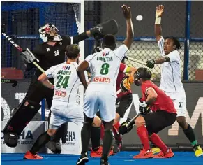  ??  ?? Alert: Canadian goalkeeper (left) clear the ball during a goalmouth melee in the match against South Africa on Sunday. The match ended 1-1.