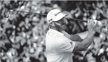  ?? PATRICK SMITH Getty Images ?? World No. 1 Dustin Johnson shot a 7-under-par 65 in the third round of the Masters on Saturday to reach 16-under 200, matching the 54-hole record Jordan Spieth set in 2015. Johnson has a four-shot lead over three players.