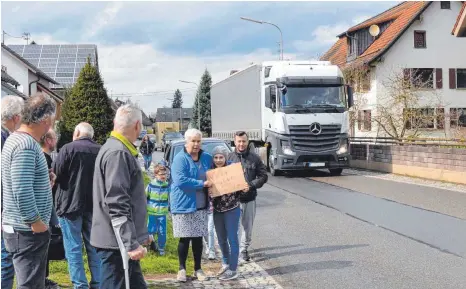  ?? FOTO: CHRISTOPH KLAWITTER ?? „Wir wollen einen Bürgerstei­g“steht auf dem Schild, während im Hintergrun­d ein Lastwagen heranfährt.