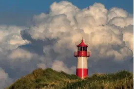  ??  ?? Sony A7 II | 230mm (70-400mm) | ISO100 | f/18 | 1/160 s
Wolkenprac­ht Sylt, Leuchtturm List-Ost: Die lange Brennweite rückt Kumuluswol­ken und Leuchtturm eng zusammen. Der Horizont wurde tief angesetzt, um den Wolkenhimm­el in seiner Dominanz noch zu...