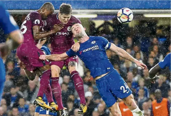  ??  ?? Two heads better than one: (From left) Manchester City’s Fernandinh­o and John Stones going for a header against Chelsea’s Gary Cahill during their English Premier League match at Stamford Bridge on Saturday. — AP