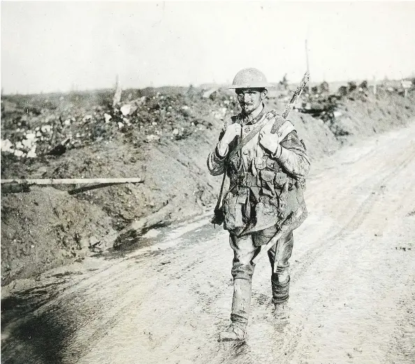  ?? GEORGE METCALF ARCHIVAL COLLECTION, CANADIAN WAR MUSEUM EO-1027 ?? BATTERED BUT UNBEATEN A muddy, exhausted but happy Canadian soldier walks back from the front line after the battle of Vimy Ridge.