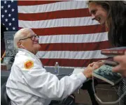  ??  ?? Pearl Harbor survivor Lt. Jim Downing, 103, shakes hands with University of Oklahoma sophomore Elizabeth Anderson after signing a copy of his book for her.