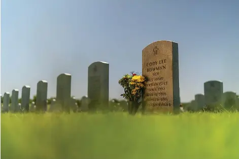  ?? (AP Photo/David Goldman) ?? The tombstone of Army Sgt. Cody Bowman stands at the Dallas-Fort Worth National Cemetery, Sunday, June 11, 2023, in Dallas. For decades, discussion­s of suicide prevention skirted fraught questions about firearms; the Army has punted implementi­ng measures that might be controvers­ial. But a growing movement has taken hold, among researcher­s, the Veterans Administra­tion, ordinary people like Bowman’s mother, Barbie Rohde, if this country wants to get serious about addressing an epidemic of suicide, it must find a way to honor veterans and active-duty service members, respect their rights to own a gun, but keep it out of their hands on their darkest days.